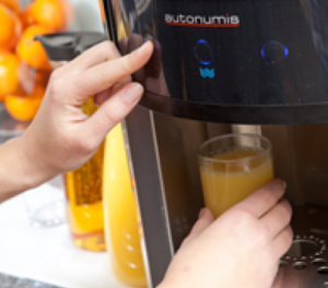 Dispenser with Juice in Glass from Oranka Juice Solutions