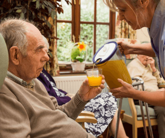 Care Home resident enjoying an orange juice from Oranka Juice Solutions